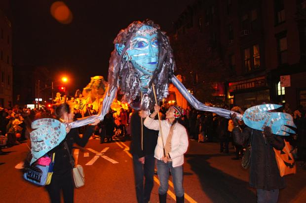 Parade goers manipulate a giant puppet