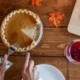 Pumpkin Pie being cut into slices on wooden table